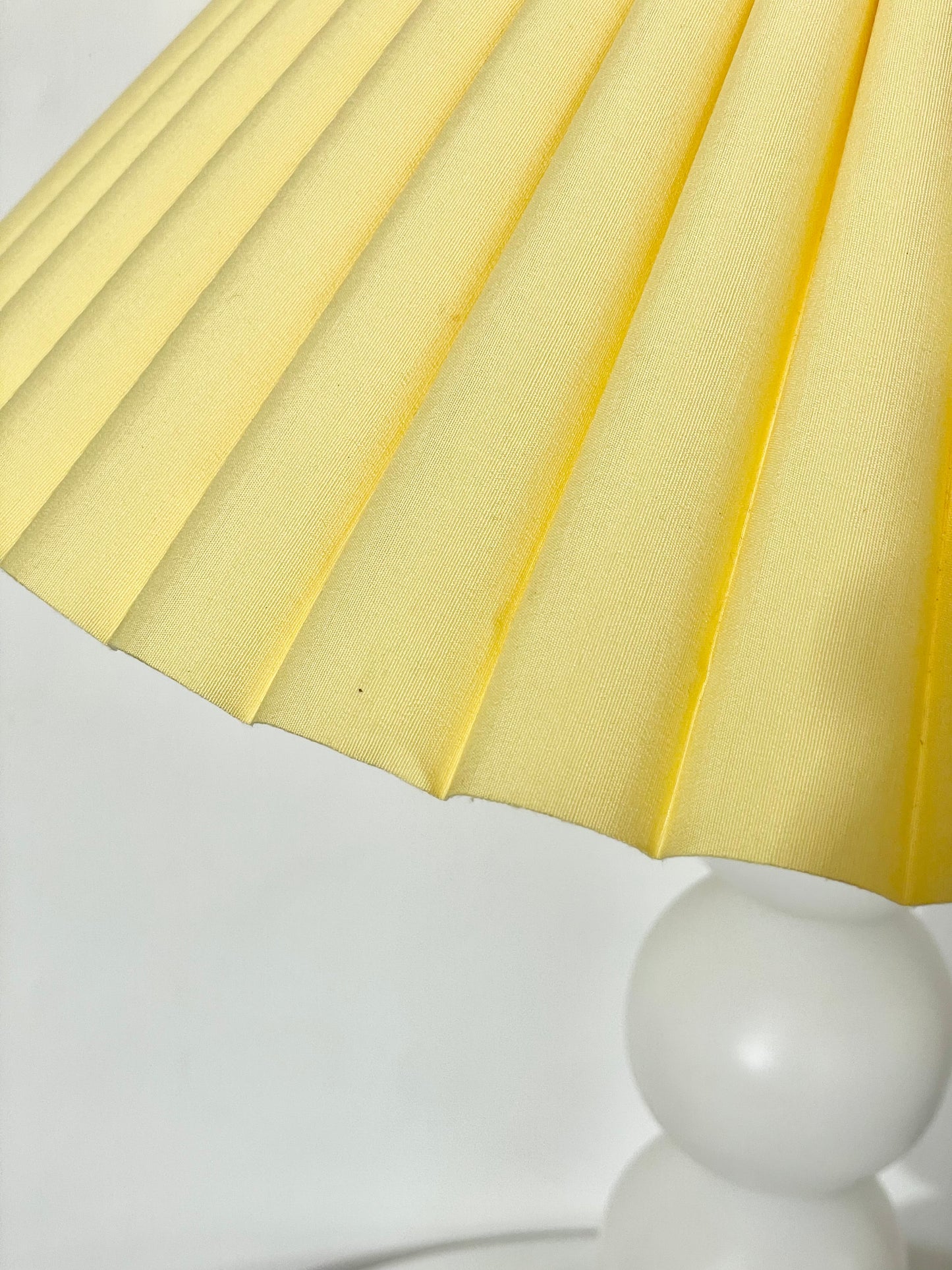 White bobbin lamp with pastel yellow shade