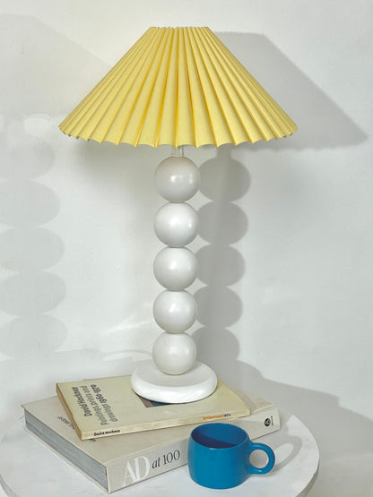 White bobbin lamp with pastel yellow shade