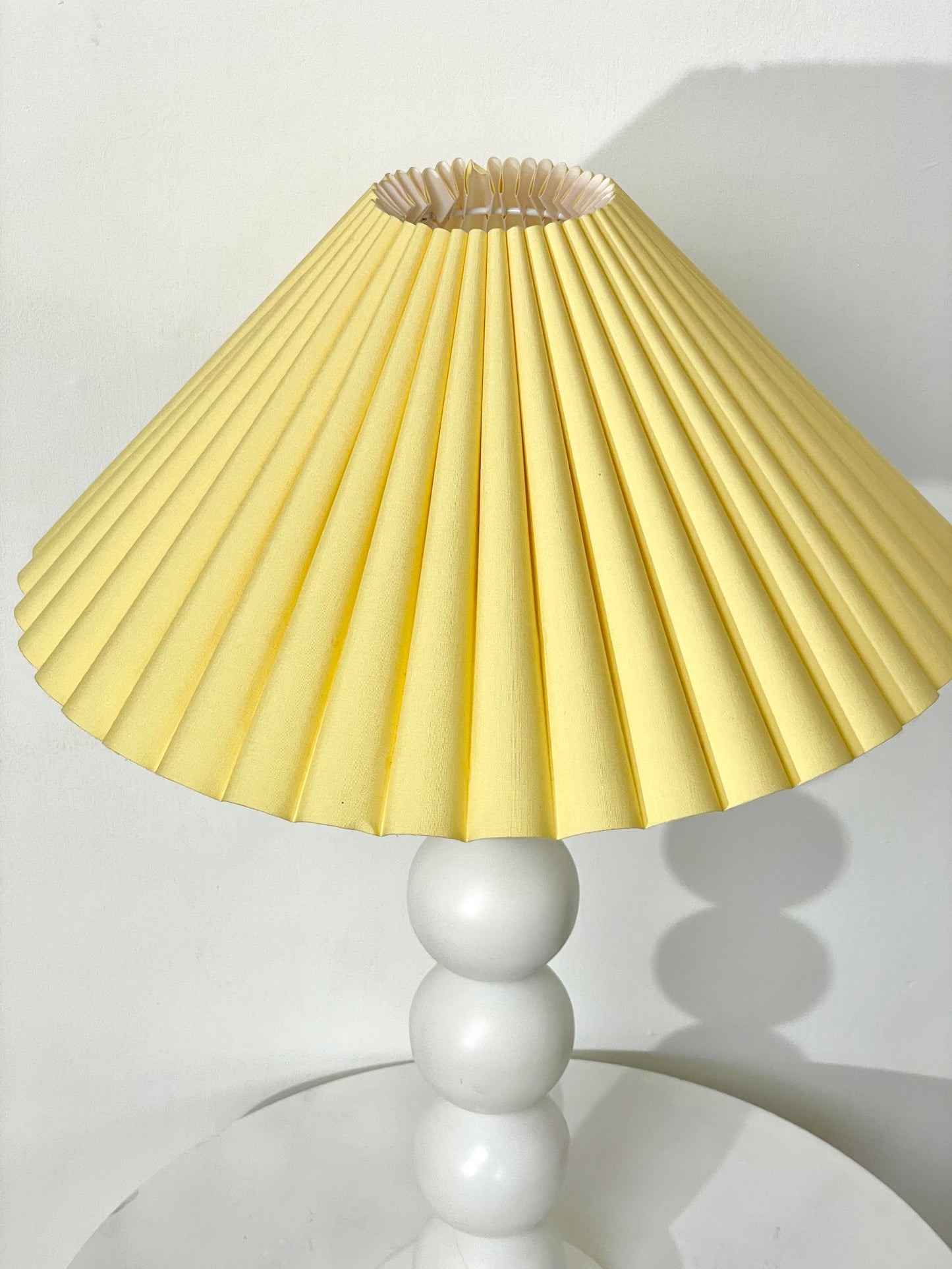 White bobbin lamp with pastel yellow shade